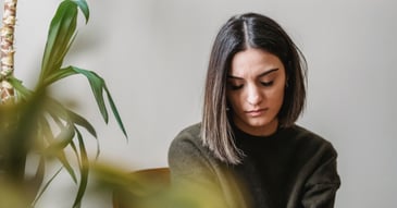 young woman on couch looking downcast
