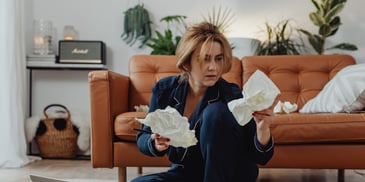 woman with adhd in pajamas overwhelmed with paperwork