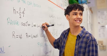 Anxious teen boy doing algebra on a whiteboard