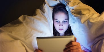 young woman on device at night using AI