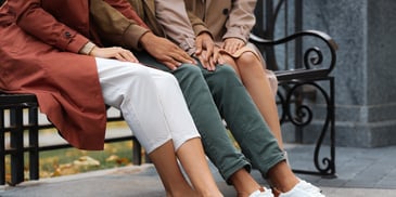 three pairs of hands held at knees in romantic partnership