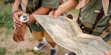 hands holding compass and map in adventure therapy