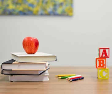 an apple above a stack of books