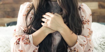 A woman putting her two hands on her chest