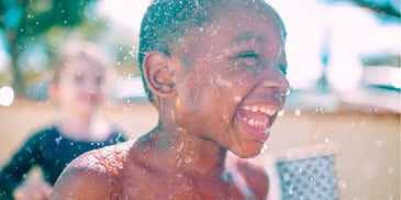 a child smiling after being wet