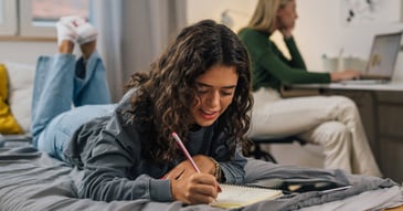 College student working with confidence in dorm room.
