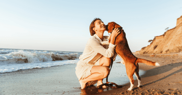 divorced woman living best life with dog at beach