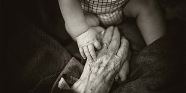 A child's hand holding an old man's hand