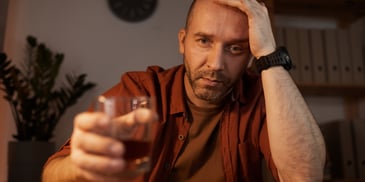 man at rock bottom drinking scotch