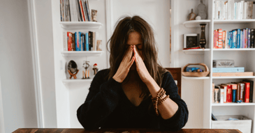 young adult in black shirt crying at college after learning of parent's divorce