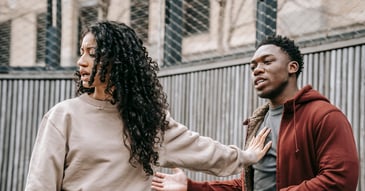 Young woman pushing away mansplainer