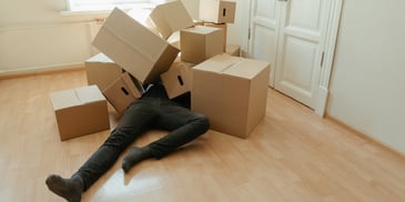 moving stress, relocation anxiety, exhausted person under moving boxes