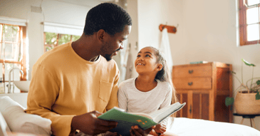 father reading book to young girl
