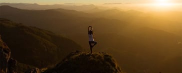 person doing yoga on a mountain. Photo by <a href=